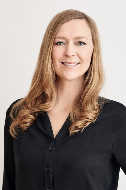 Lächelnde Frau mit langen, blonden Haaren und einer schwarzen Bluse - Sonja Eschenberg